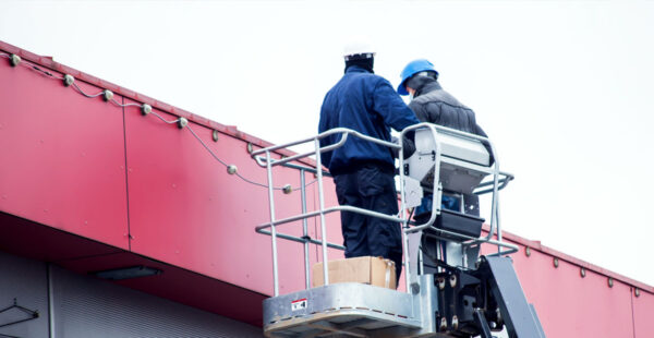 two men using a cherry picker