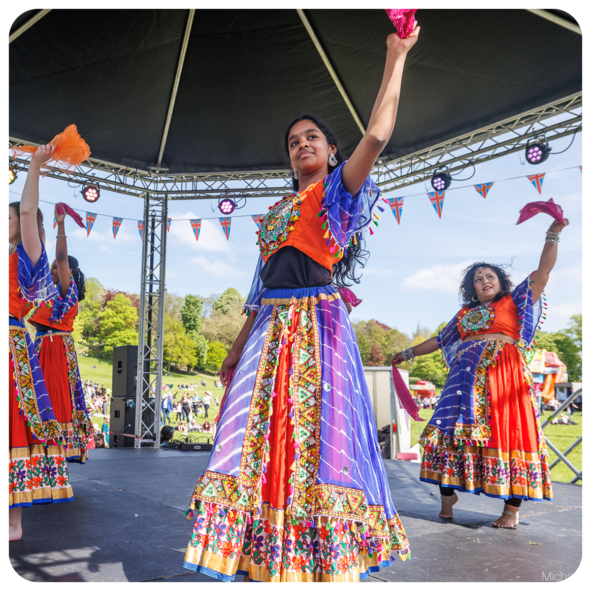 Ladies dancing on a bandstand at the King's coronation event